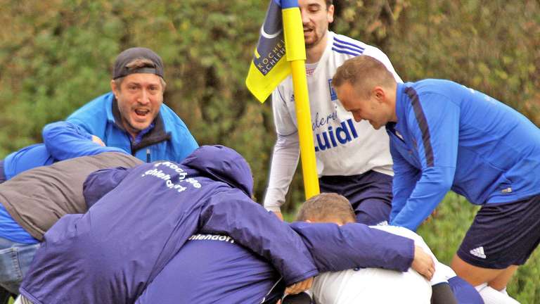 Eine Jubeltraube bildet sich nach dem Abpfiff bei den Kochelsee-Kickern. Schlehdorfs Trainer Maximilian Jochner (hinten l.) ist mitten drin. Foto: rabuser © rabuser